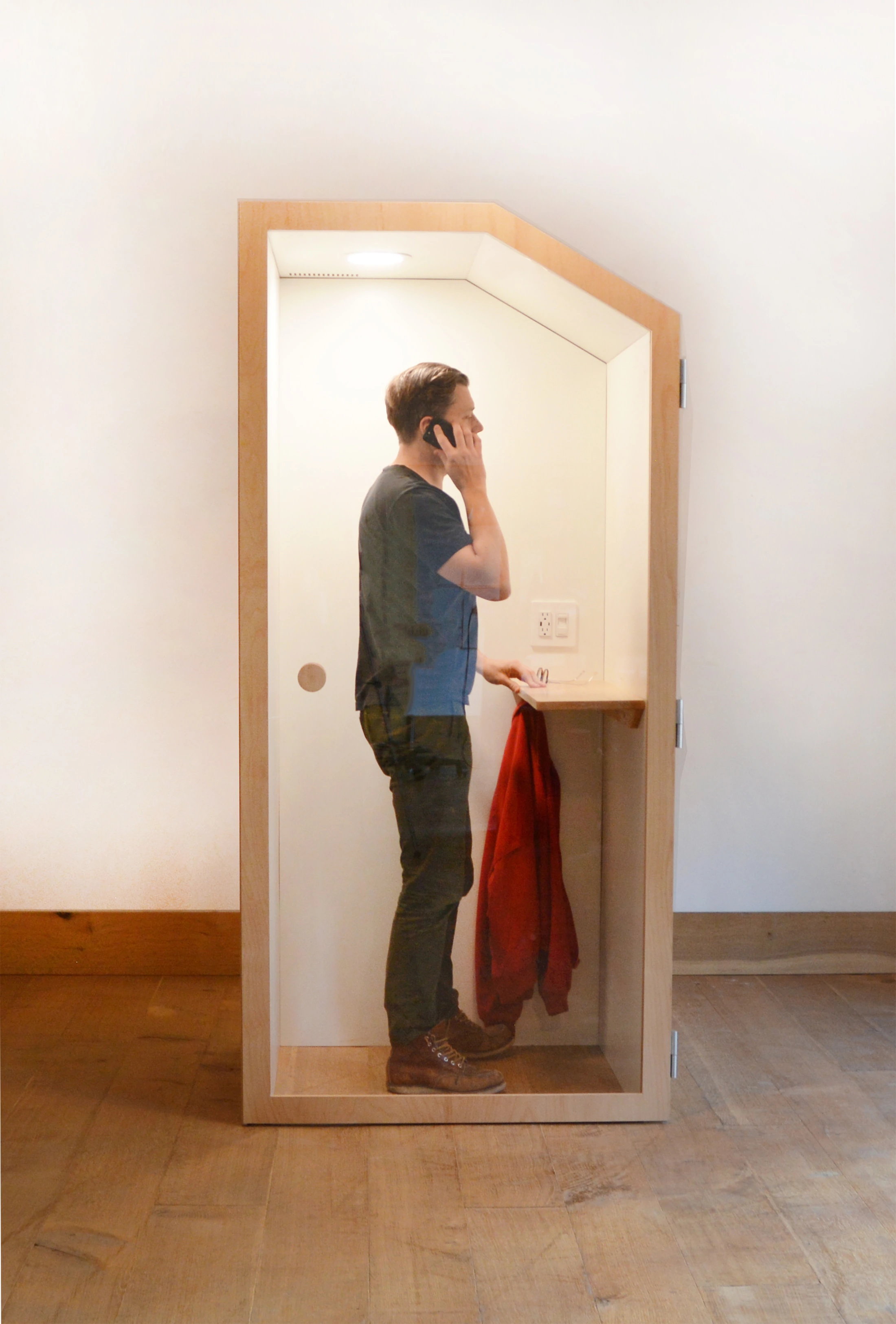 A person standing inside an OpenBooth — fully transparent front door