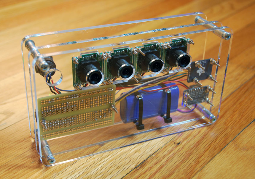 Front of the camera — four lens holes in acrylic.