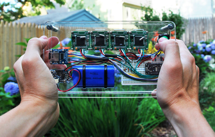 The stereoscopic camera in action — three sheets of acrylic sandwiching a four-camera circuit.